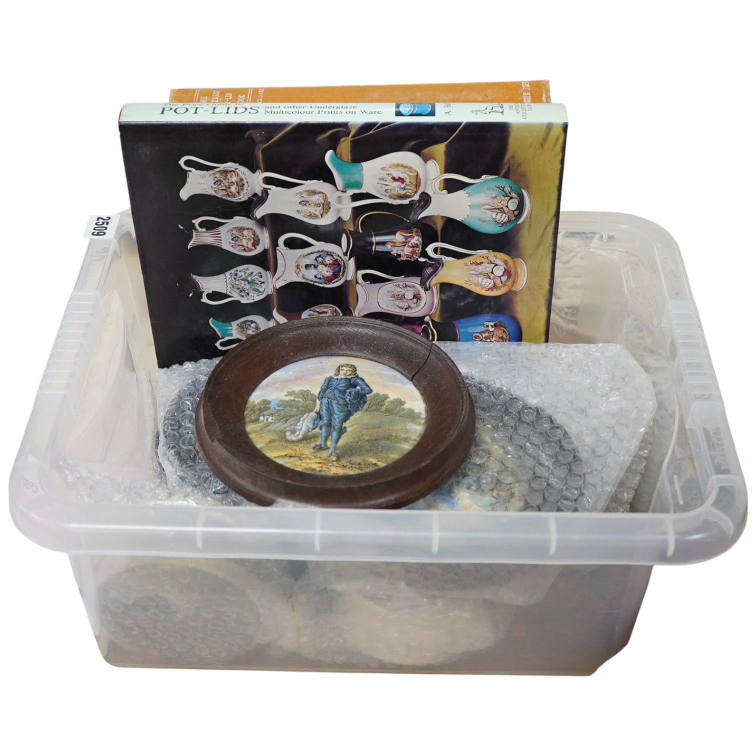 A group of ten pot lids and two related books